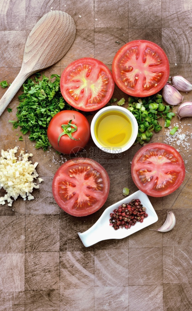 木板上安排的西红柿草药大蒜和油夏天安排好的番茄图片