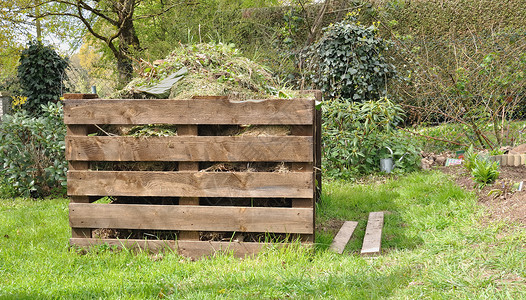 堆肥草自然在花园里装满废物的木制板壁炉背景图片