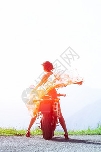 向观看摩托车上的女人站着戴围巾朝太阳走来逃脱图片