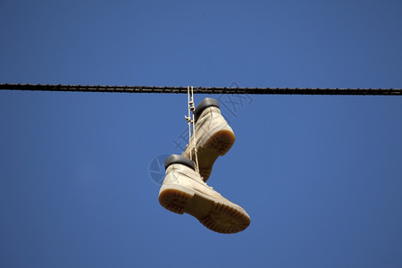 鞋挂在铁线上城市的绞刑靴子图片