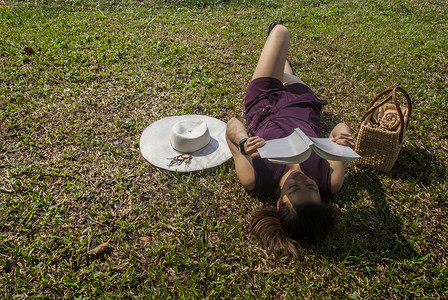 躺在草坪上看书的女士图片