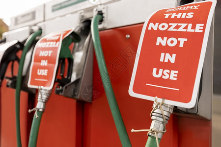 前院车库人们燃料短缺期间封闭油气站泵的标志背景图片
