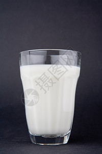 超过填充深灰色底面玻璃中的牛奶白色背景图片