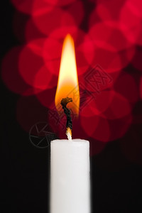 硬脂一个白蜡烛烧着红色闪发光的背景红色燃烧背景图片