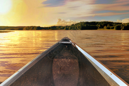 在黄昏中划水的独木船背景图片