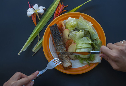 黑桌上有蔬菜沙拉的牛排配桌子花三文鱼背景图片