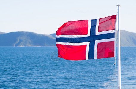 扶着旗帜军人挪威在蓝天上挥舞着挪威动摇民一种背景
