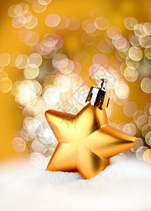 雪丰富多彩的金色圣诞装饰明星在bokeh背景金色的Bokeh光效应圣诞节背景图片