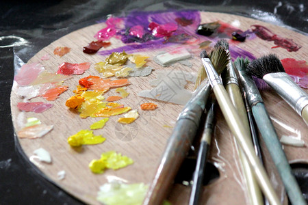 木制的艺术材料家在木调色盘上的油漆刷子艺术绘画图片