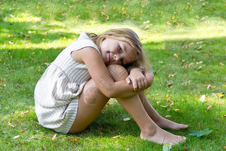 坐在绿草地上的可爱女孩图片