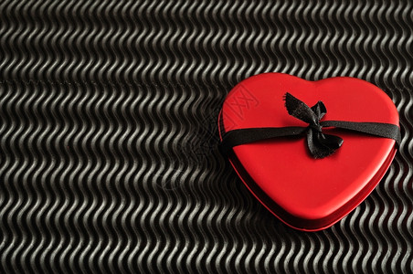快乐的黑色红心与丝带连在一起被黑色背景隔离的丝带绑在一起浪漫图片