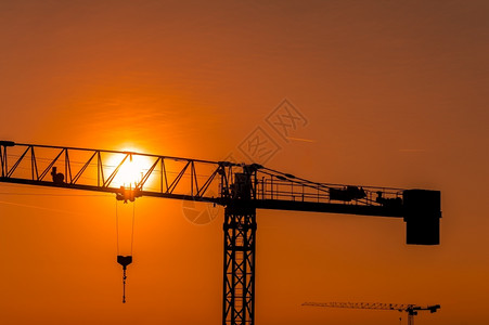 日落或出时建筑工地的起重塔船厂轮廓财产背景图片