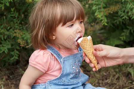 吃冰激凌的小女孩户外高清图片素材