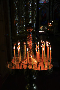 信仰教堂的烛台上蜡在黑暗中燃烧图片
