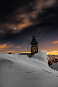 黑暗的被积雪覆盖阿尔卑斯山教堂霜冬天图片