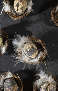 篮子巢中的鸡蛋和白羽毛中的鸡蛋复活节概念暗底有小鸡蛋传统的食物图片