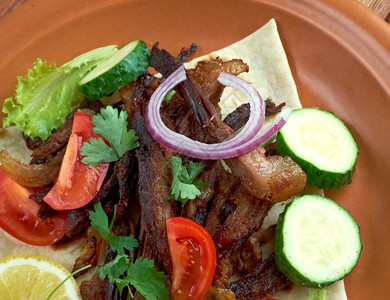 美食with绿色红的Carnitas墨西哥菜配猪肉西红柿和蔬菜图片