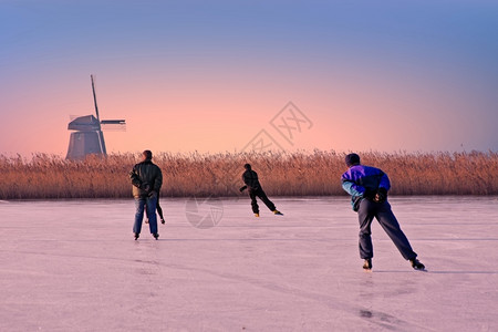 人们建造日落时从荷兰滑冰在农村的溜冬天图片