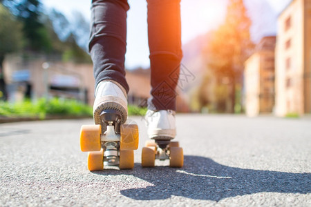 快速地旅行滑雪鞋和日光束贴上滚式滑冰鞋街道图片