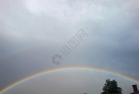 明亮的雨后彩虹升起云深的背景图片