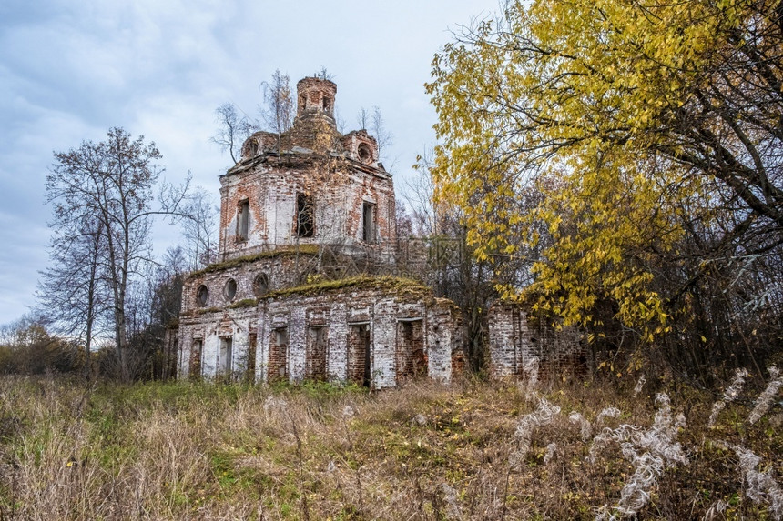建造毁坏在秋天阴云的俄罗斯一座破旧的红砖教堂毁了图片
