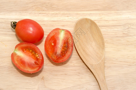 红色的木头上勺子和番茄木制的甜背景图片