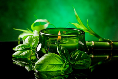 绿色树叶黑色玻璃桌上有香味的蜡烛照片图片