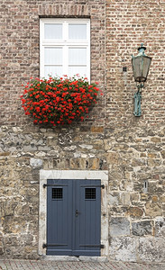 石头屋优质的带有红花和窗户的房门入口图片