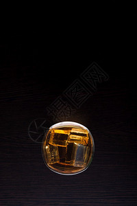 液体苏格兰人玻璃中威士忌的顶部视图黑底有冰酒图片
