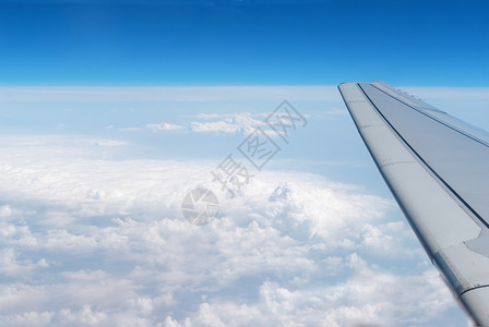 平流层移动地线蓝云中的飞机翅膀图片