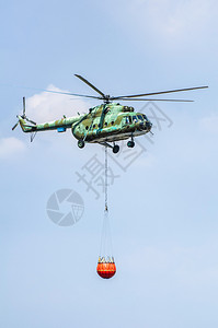 熄灭航空运送水的绿色消防直升机灭火扑灾难背景图片