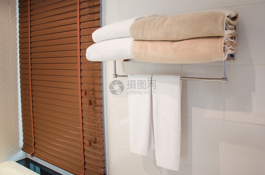 洗澡衣架轨挂在浴室毛巾栏杆上的图片