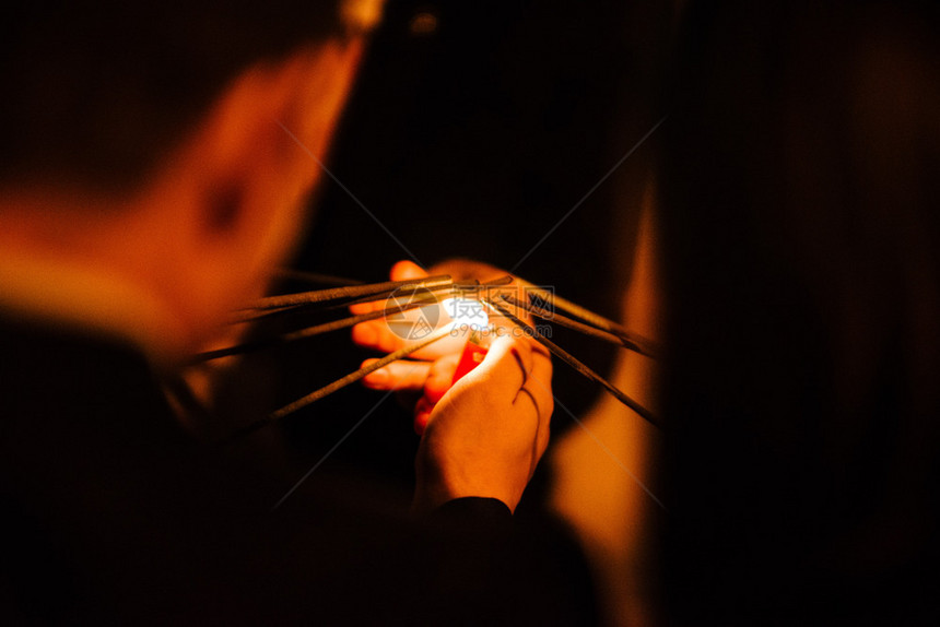 燃烧庆典一个男人拿着烟火打机点燃孟加拉的灯光晚上紧地点亮一个男人着火花筒A男人用烟火打机点燃了夜晚的火花灾图片