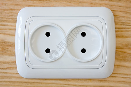 目的瓦数木墙上白色电插口紧闭的白色电源别针图片
