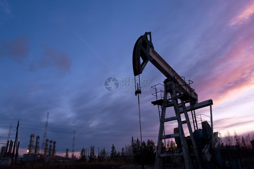 工业地貌和日落天空背景的石油泵抽机轮廓汽图片