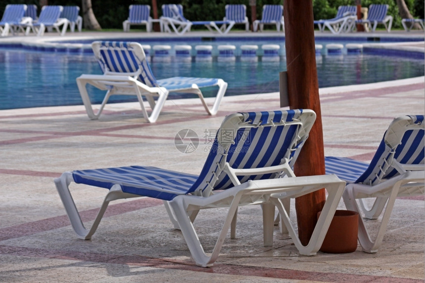 水池家具坐在一个大型游泳池旁的度假村休息室座位旁的闲椅客户图片