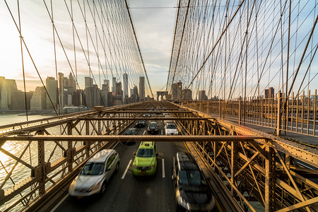 团结的美国商业和运输概念纽约市景背的布鲁克林桥上日落商业与交通概念在工作日下班后的高峰时交车人们城市背景图片