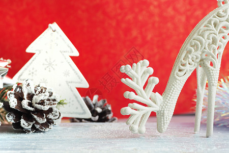 圣诞节霜灰色木背景上的圣诞玩具鹿和树锥壳铁锡轮和人工雪明信片图片