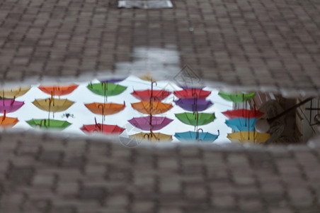 在街道伞状通上一个水坑中反射雨伞里戈建造一种高清图片