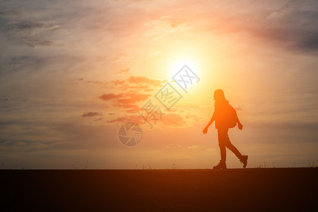 女士自由带着背包的爬山者放松和享受日落假期图片