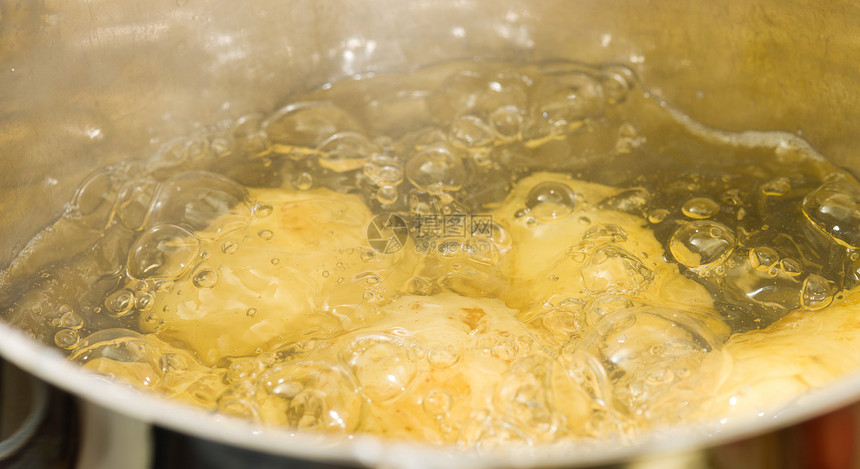 蔬菜整个马铃薯在不覆盖的锈钢锅中沸腾水平的底锅图片