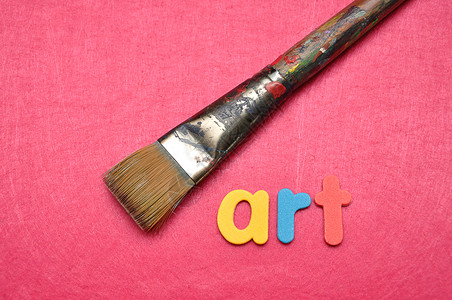 画家水彩粉红色背景的画笔上面写着艺术目的图片