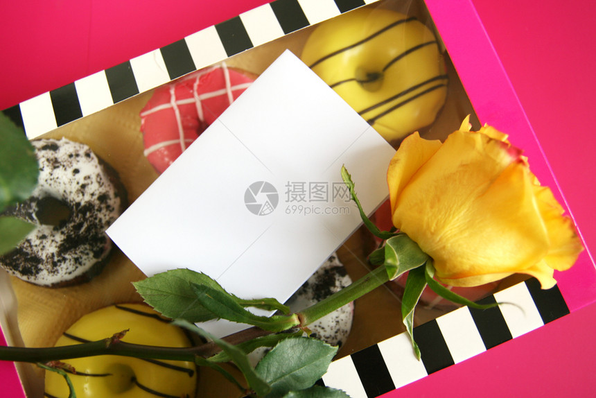 赞扬最佳一个黑白条纹盒子粉红背景上6个多色甜圈上面有一朵黄玫瑰和张空白纸种图片