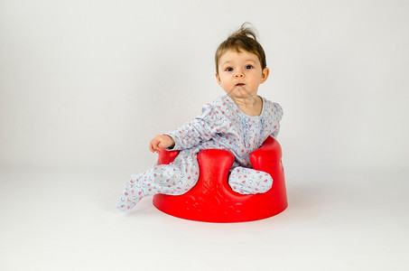 坐在椅子上的可爱婴儿红色的高清图片素材