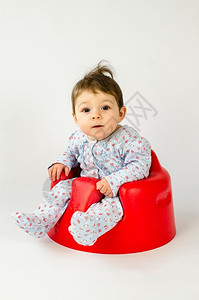 可爱的小女孩坐在红色小凳子上座位高清图片素材