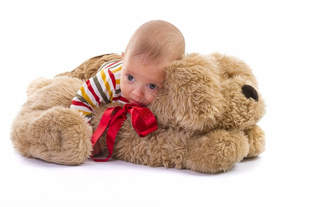趴在玩具熊上的婴儿微笑高清图片素材