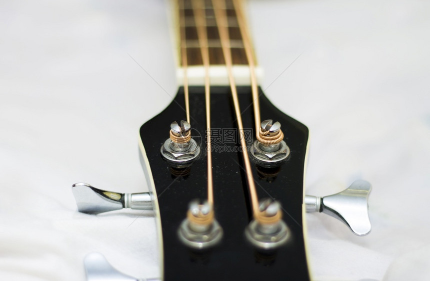 拇指细绳一部音响贝斯吉他特写在白色背景上被隔离低音图片