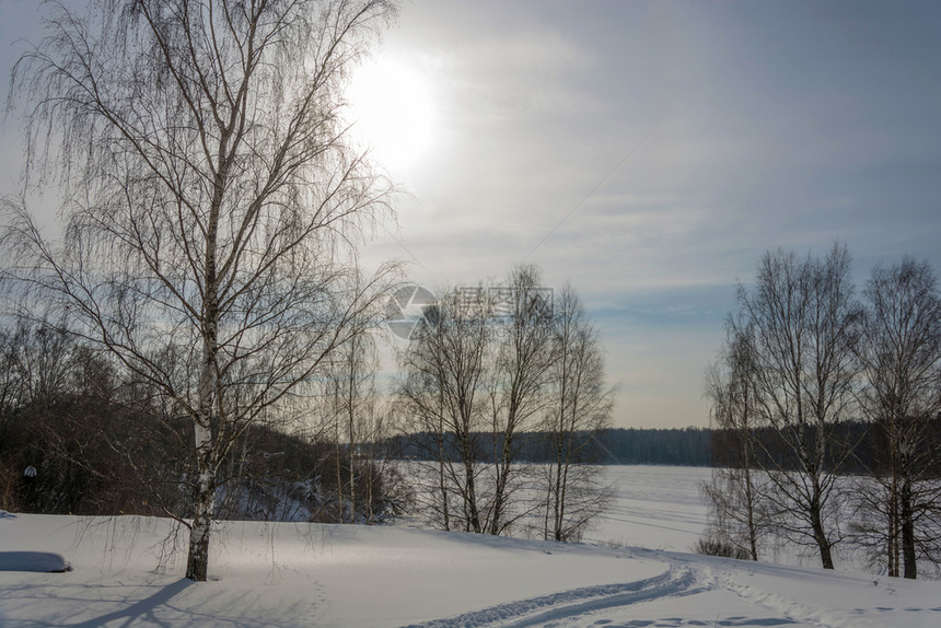 云太阳寒冷的美丽冬季风景光线照亮阳日落时有雪斜坡和鱼圈图片