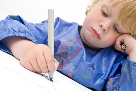 笔蓝色的金发悲哀看着孩子做一个绘画用触觉视网膜聚焦在感触手脚盘和上染色高清图片素材