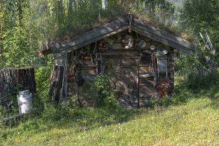 木头旧屋有很多锌制设备如锅罐子和其他旅行草夏天高清图片素材